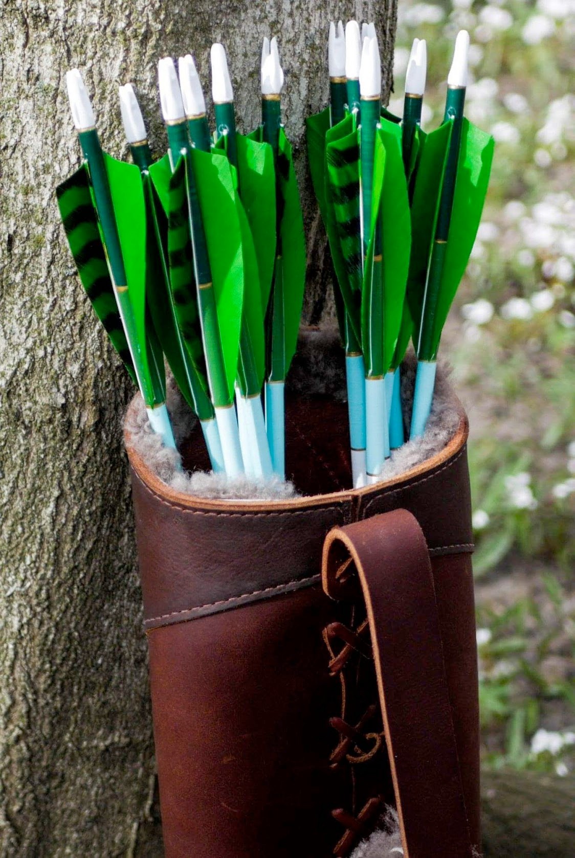 Green fletched arrows in a handmade leather quiver