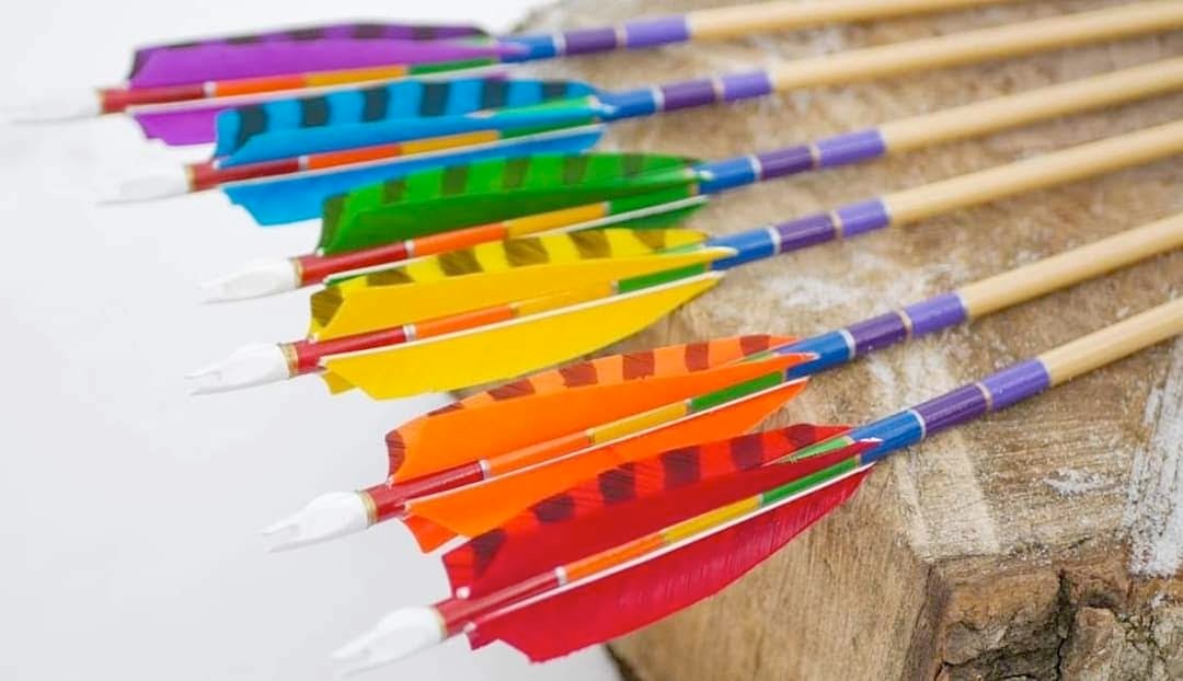 Rainbow-colored fletched arrows with vibrant dyed feathers