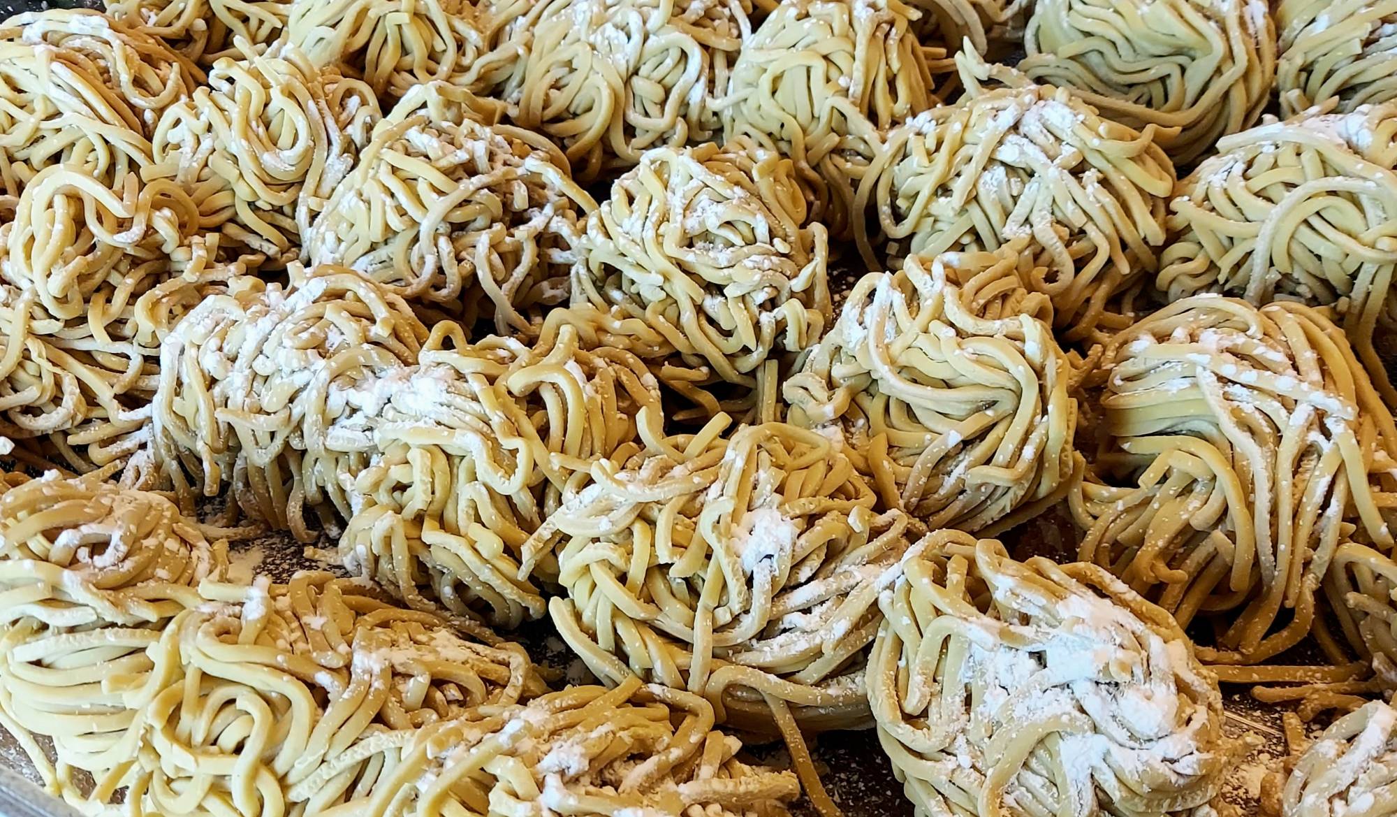 Fresh handmade ramen noodles dusted with flour, ready to cook