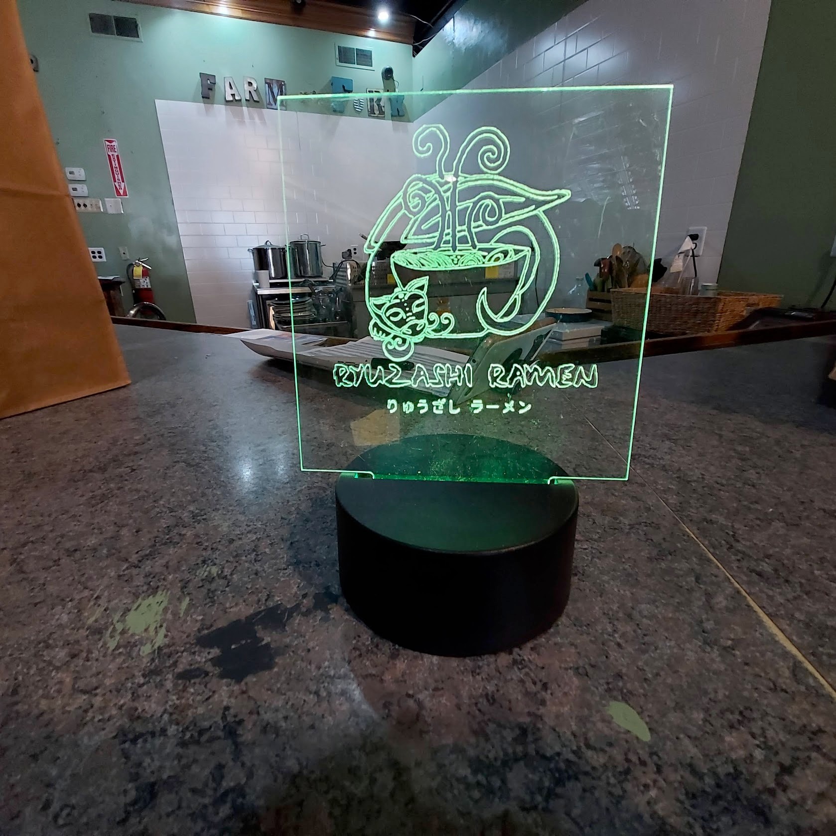 LED-etched Ryuzashi Ramen sign glowing green at the pop-up venue