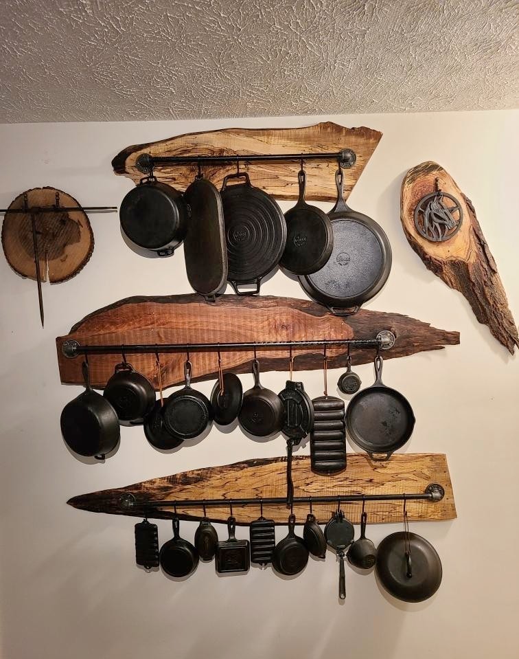 Live-edge slab wall rack displaying a cast iron collection