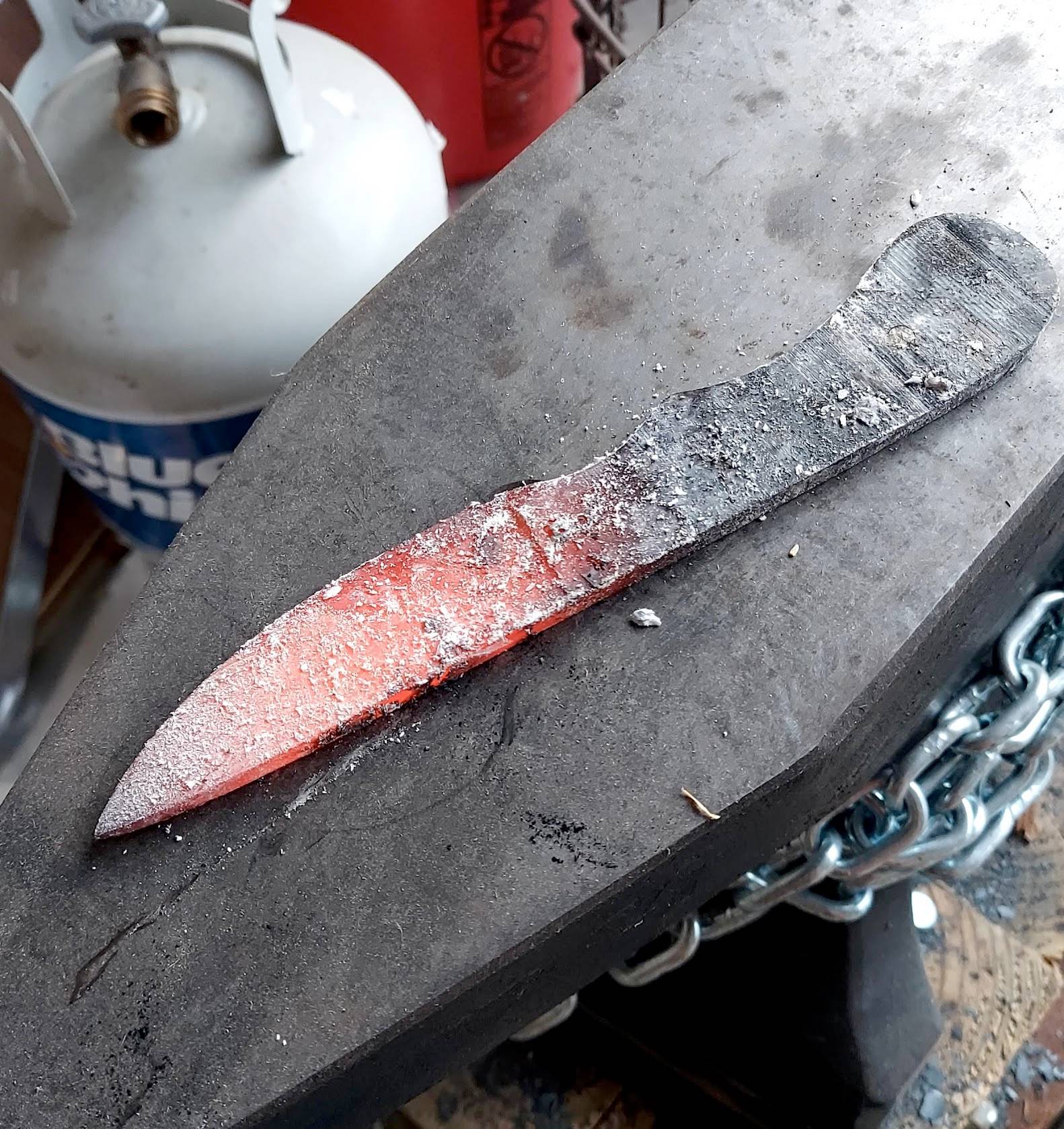 Freshly forged knife blade cooling on the anvil