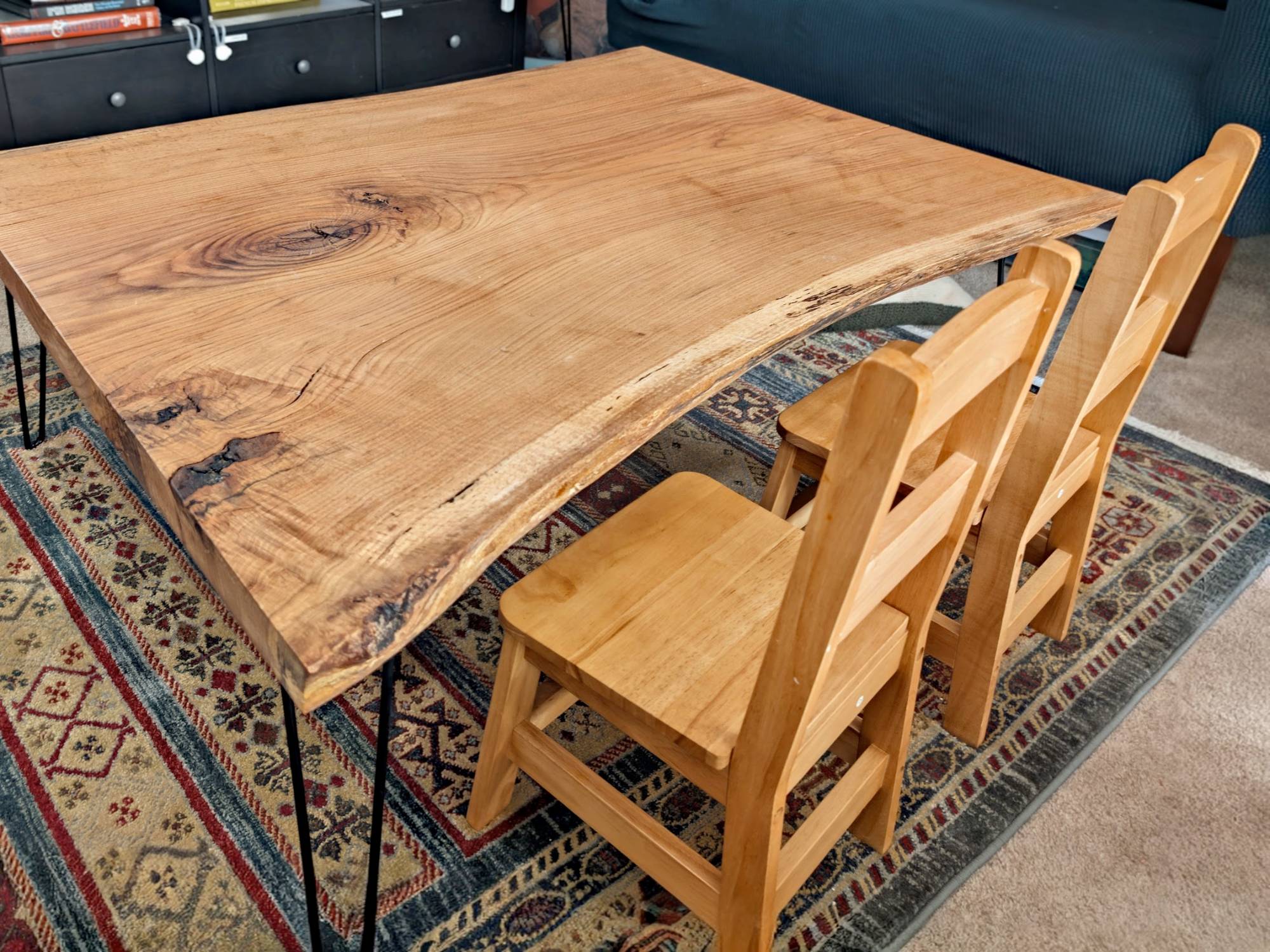 Live-edge oak dining table with hairpin legs and wooden chairs