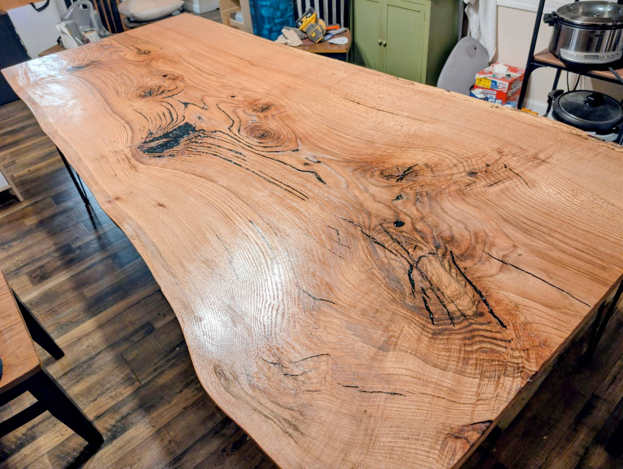 Live-edge oak slab dining table with epoxy-filled cracks — freshly finished