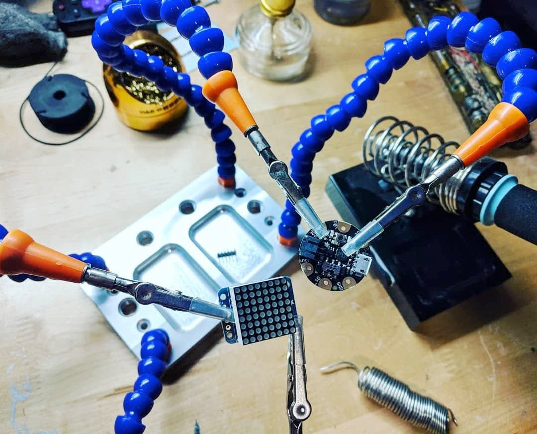 Soldering a microcontroller and perfboard on the workbench